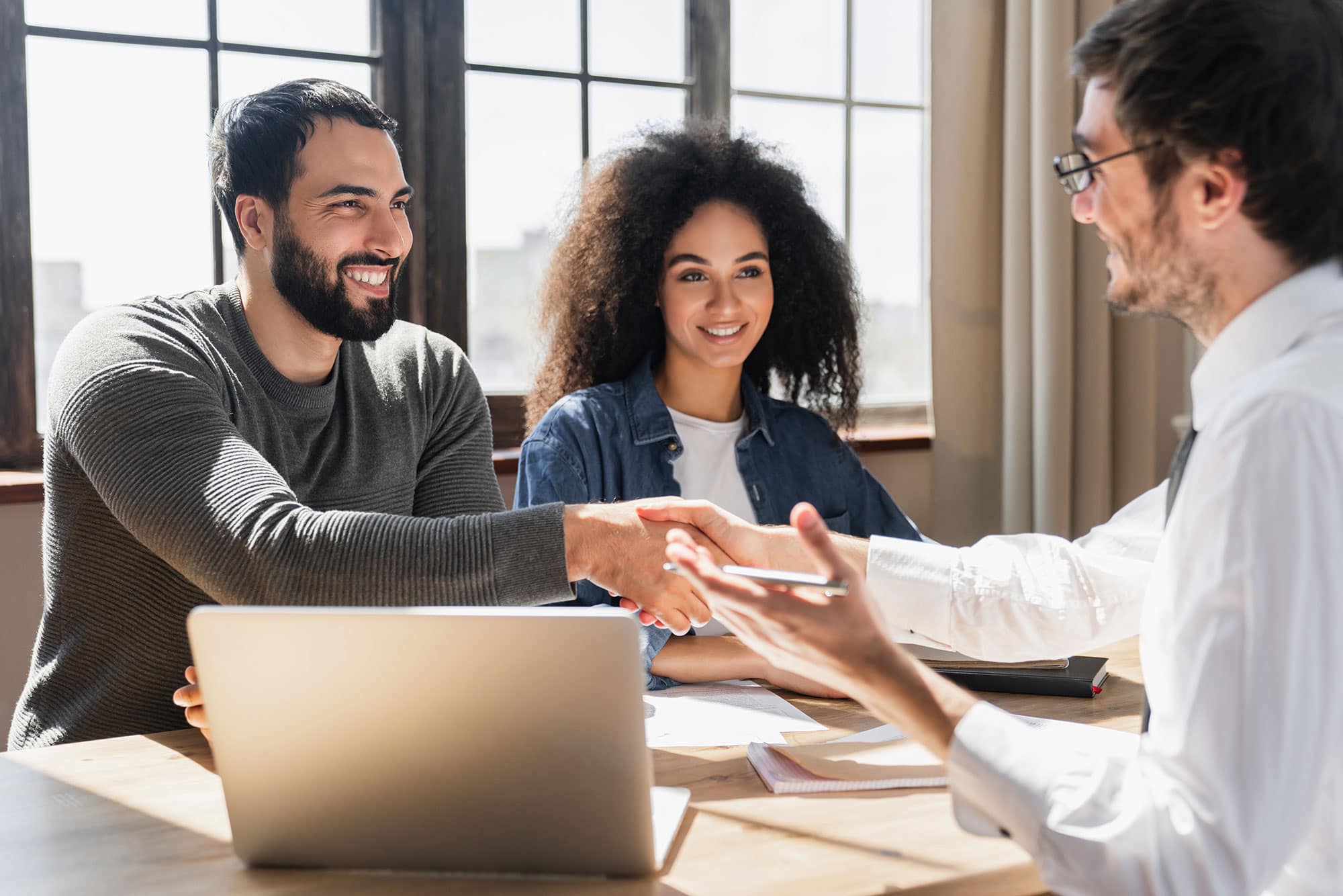 A couple speaking to an advisor at a table with a laptop